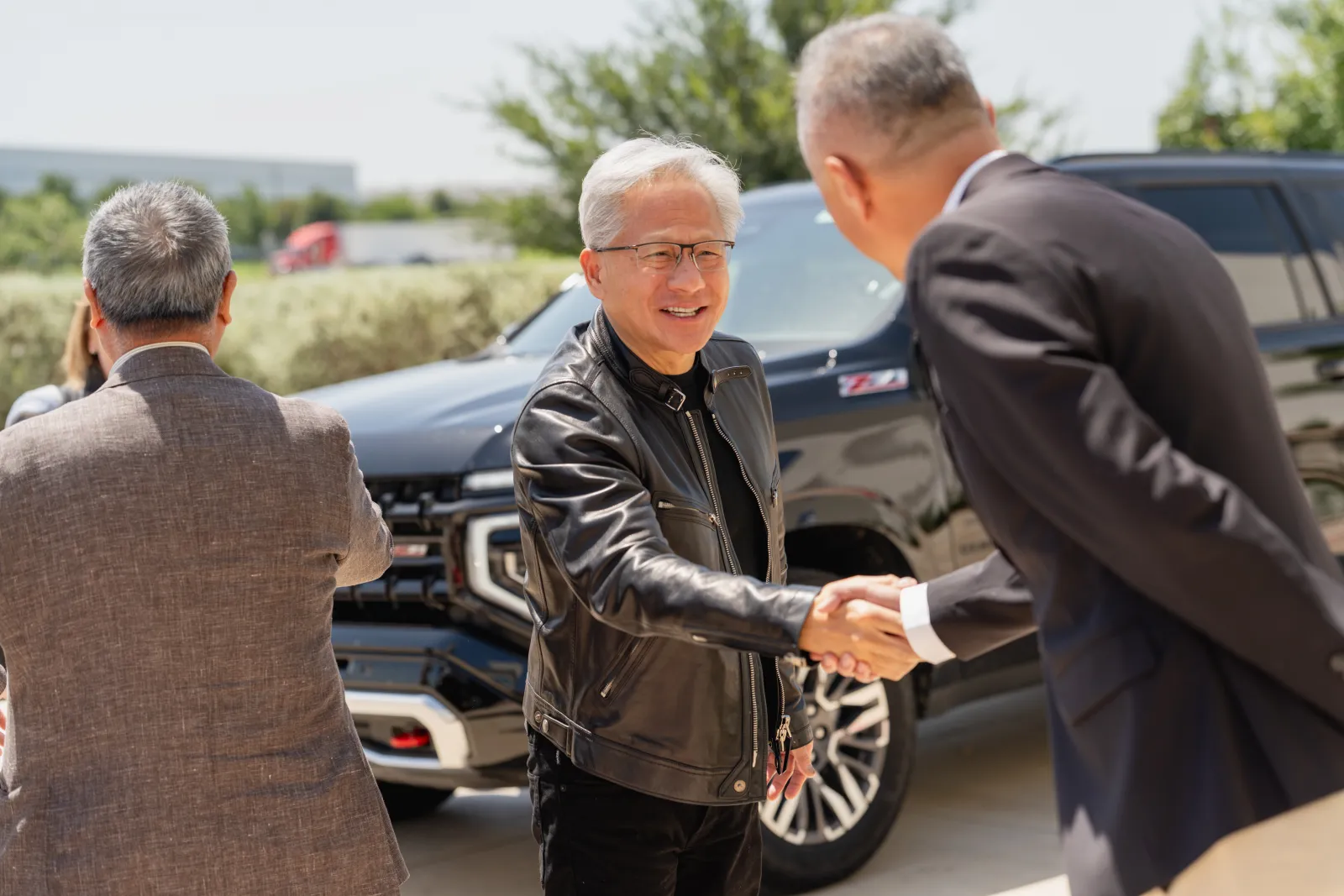NVIDIA CEO Jensen Huang shaking hands outside the Wistron D1 facility