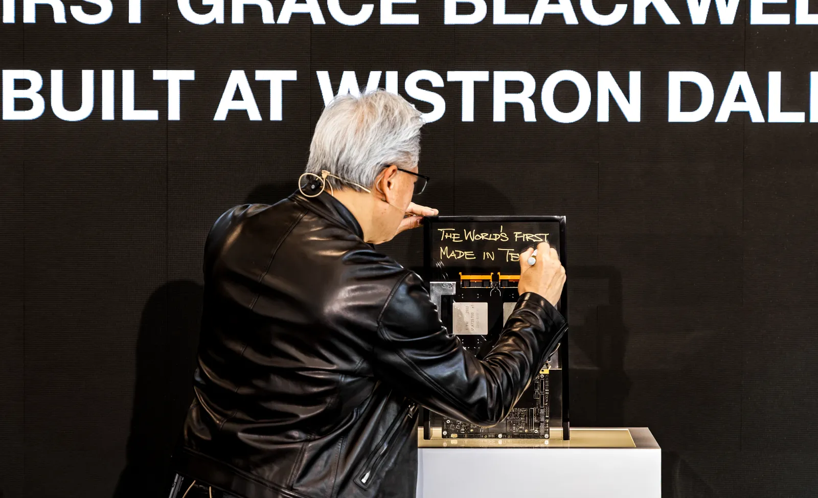 NVIDIA CEO Jensen Huang signing hardware on stage at the Wistron D1 Grand Opening Ceremony